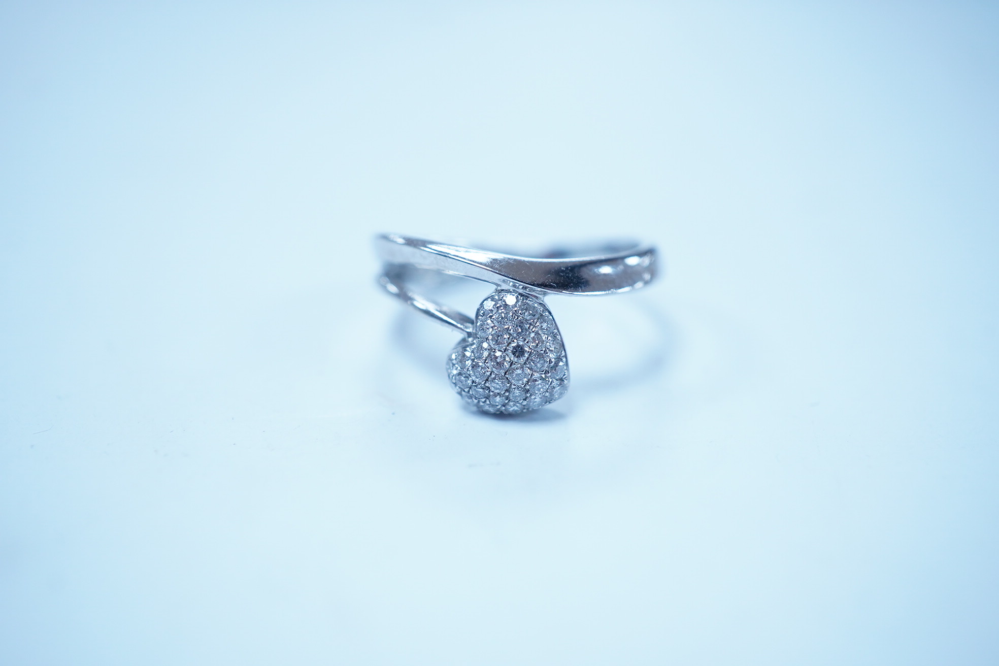 A modern 18k white metal and pave diamond set heart shaped ring, size H, gross weight 2.1 grams. Condition - good